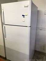Full front view of white Frigidaire refrigerator showing top freezer and lower refrigerator sections.