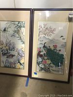 Two framed Asian-style paintings with birds, flowers, and landscapes side by side.