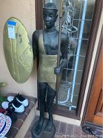 Full frontal view of metal sentry statue on front porch