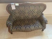 Front view of the upholstered doll sofa showing fabric pattern and wooden frame