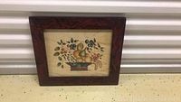 Framed theorem painting depicting a fruit basket arrangement by artist Ann Rea, featuring pears, grapes, berries, leaves, and flowers in soft colors on a cream background with a dark carved wooden frame.