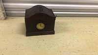Wooden storage box with a clock face on the front showing its design and condition