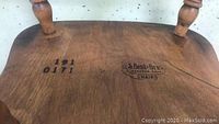 Close-up of the underside of the antique wooden chair showing S Bent Bros Massachusetts branding with numbers 492 0171 stamped in black ink.