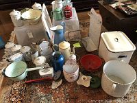 Group view of enamelware items including canisters, pitchers, bowls, colanders, covered pan and accessories