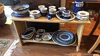 Shelf overview with multiple bowls, platters, mugs and teapot