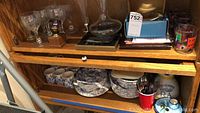 Various dishes, plates, bowls and cups from Copeland & Garrett Spode Company china with some cutlery and other glassware on shelf.