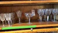 Overview of all glasses on wooden shelf showing mixed styles