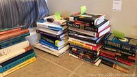 Multiple stacks of books including fiction, management, business and Six Sigma references