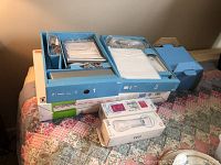 Top-down view of the Nintendo Wii console and accessories boxed and laying on a quilted surface.