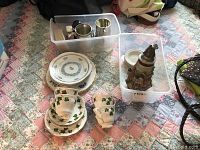 Overview of lot showing German beer stein, Colelough tea set cups and saucers, Royal Vale and Volkstedt plates, salt and pepper shakers in plastic bins.