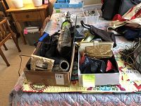 Overall view of assorted handbags, purses, clutch bags in boxes on a table.