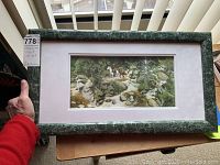Photo showing framed Bev Doolittle print held in hand with visible frame and label.