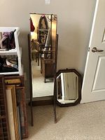 Full-length vintage dressing mirror with wooden stand and rectangular shape in a room corner