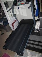 Side view of NordicTrack treadmill showing running belt, folding frame, and part of room around it.