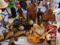 Photo showing Twin Winton gingerbread house cookie jar, globe bookends, figurines including a seated man and dog, candles, candle holders, wooden plaques, and wall decorations.