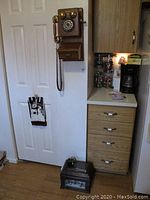 Full view of the Thomas Collector's Edition wall telephone mounted on wall near kitchen area plus Mr. Christmas music box on floor