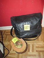 Vintage black Spirit branded bag with label reading 'Scrapbooking Supplies' and vintage sewing kit tin with yellow note 'Sewing Kit'. The bag appears worn with visible wear on corners.