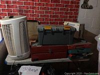 Photo showing Pioneer DEH43 car stereo box, Enviracare air purifier, metal and plastic toolboxes positioned on a table against a brick pattern wall
