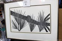 Framed black and white print with palm leaf design, showing overall artwork and frame.