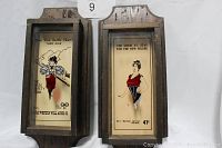 Pair of vintage wooden framed glass wall plaques with illustrated vintage prints inside, showing colorful women in mid-century style outfits with promotional captions and prices.