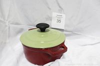 Red Chasseur cast iron coated pot with baked enamel and light green Invicta lid on a white background