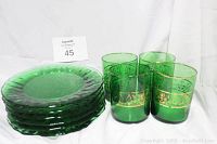 Set of 6 vintage green textured glass plates stacked beside 4 green glasses with gold etched floral trim.