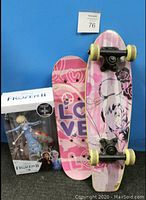 Two girls' skateboards and Frozen 2 Elsa doll in box on blue background