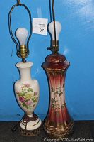 Side view of two vintage floral lamps showing porcelain bodies and brass bases.