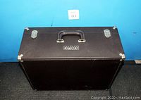 Top view of closed vintage brown luggage showing metal handle and two metal latches with corner protectors