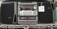 Full view of AIWA stereo system including main unit and two speakers on metal rack.