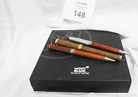 Top-down photo of three wooden finished pens on black Montblanc box, showing brand logo.