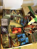 Box of Star Wars collector cards including plastic sleeved cards and sealed game packs