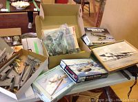 Photo showing multiple model airplane kits on a table including Westland Whirlwind, Miles Magister, and other partially assembled models.