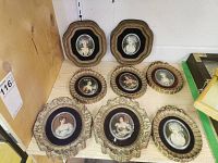 Wide view of 8 varied shaped and styled framed vintage portraits on shelf, showing size and wear.