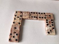 Marble domino tiles arranged to show detail of material and black circular pips.