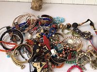 Large pile of mixed costume jewelry including bracelets, necklaces, and earrings in various colors and materials