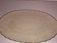 Front view of oval Lenox serving platter showing embossed grapevine pattern with scalloped gold rim.