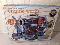 Front view of boxed Engine Works 4-cylinder model engine by Discovery Kids showing product name, transparent engine model image, and key features like spark plugs firing.