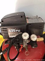 Side view of Porter Cable 135 PSI pancake air compressor showing gauges, regulator, and power cord.