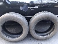 Two Continental Contact tires standing upright, side view showing size and branding.