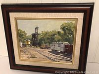 Full view of framed oil painting depicting a train station with rail cars and trees.