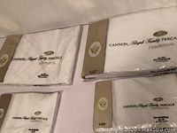 Four packs of white Cannon Royal Family Percale bedding and pillowcases arranged on a surface, packaging visible with print labels.