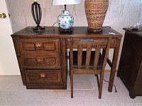 Wooden desk with three drawers and matching wooden chair, both with visible surface wear and scratches.