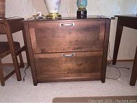 Front view of larger wood file cabinet with two drawers showing wood grain finish, some marks visible