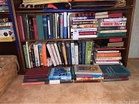 Books arranged on shelves with a mixture of hardcover and paperback covering religion, self help, educational, and novels. Condition shows wear, tear, stains, and marks.