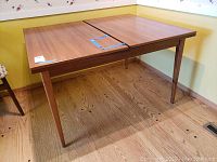 Full view of the mid century wooden dining table with expandable top, showing the table in an extended position.