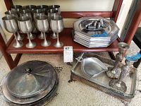 Wide view of all items showing goblet wine cups, plates, salt and pepper shakers, candle stick holders, and serving tray with covered dish