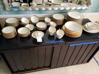 Full view of all china pieces arranged on table showing stacked plates, bowls, saucers, cups