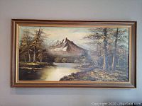 Full view of the framed oil painting showing the mountain, forest, and water landscape.