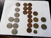 All coins laid out on white background, various denominations visible including 1p, 2p, 5p, 10p, 20p, 50p, and 1 pound coins.